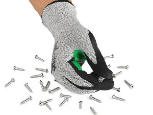 Hand wearing a cut-resistant glove holding a green tool with screws scattered around on a white background