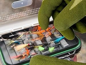 Fishing lures in a tackle box with a gloved hand holding it