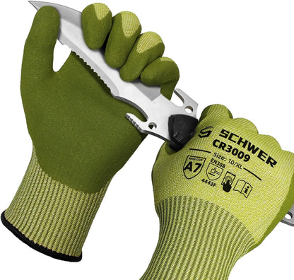 Pair of green Schwer CR3009 protective cut resistant work gloves holding a serrated knife