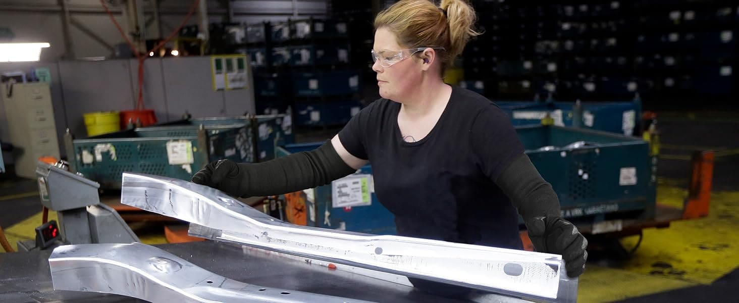 Person working with metal components in a warehouse setting