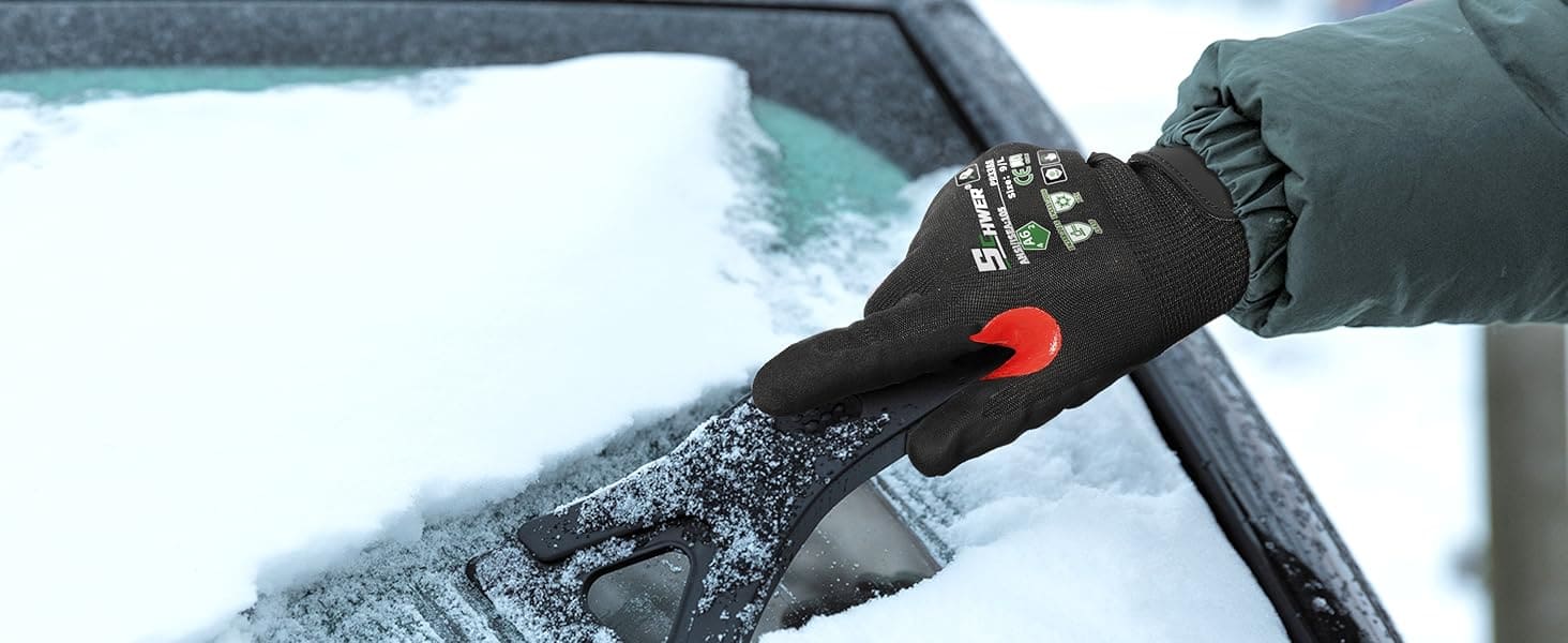 Person using a snow scraper on a car window with a glove on