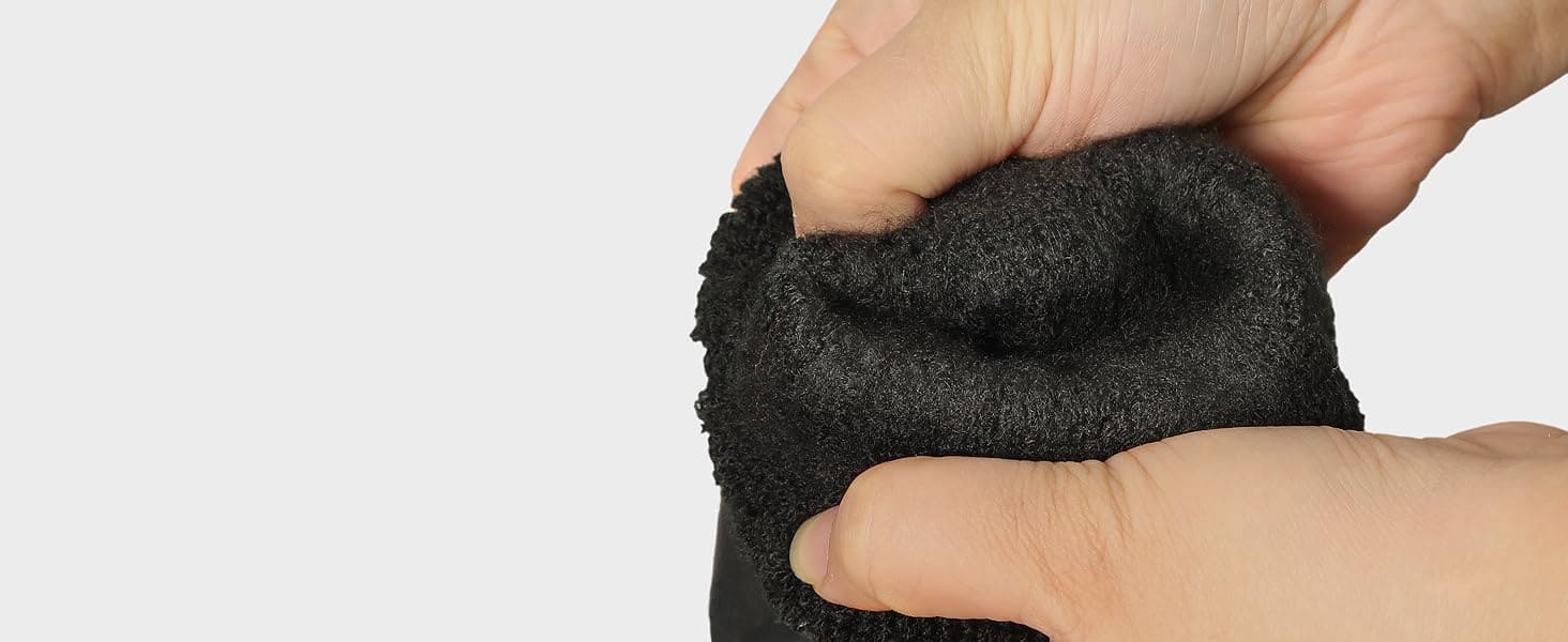 Hand holding a black textured object against a light gray background