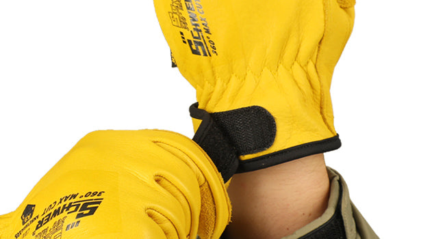 Yellow gloves with black straps worn on a white background