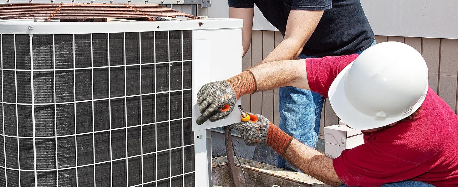 Two workers working on an air conditioning unit outdoors.