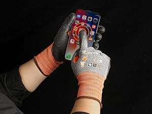 Person using a smartphone with futuristic gloves on a black background
