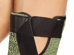 Close-up of a person wearing a green and black patterned garment with a blurred background