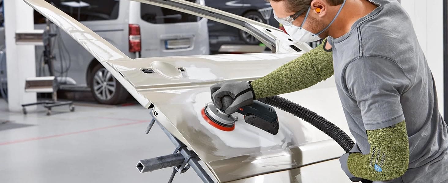 Person using a tool on a car door in a workshop setting