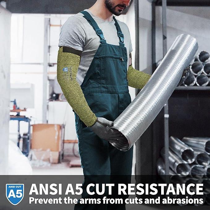 Worker in green cut resistant arm sleeves holding large metal duct in industrial setting