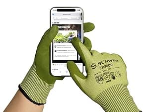 Person wearing green gardening gloves using a smartphone with an app on the screen.