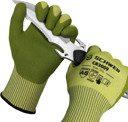 Pair of green Schwer CR3009 protective cut resistant work gloves holding a serrated knife