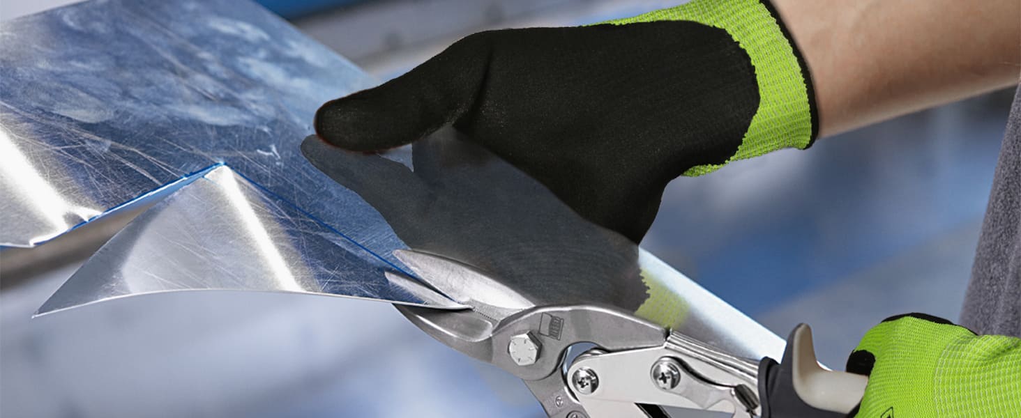 Person wearing green and black gloves using a tool on a metallic surface