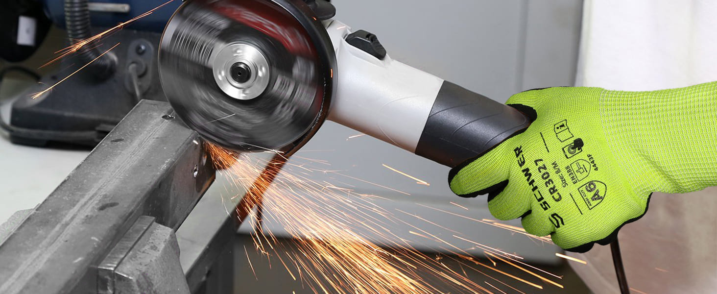 Person wearing a green glove using an angle grinder with sparks flying