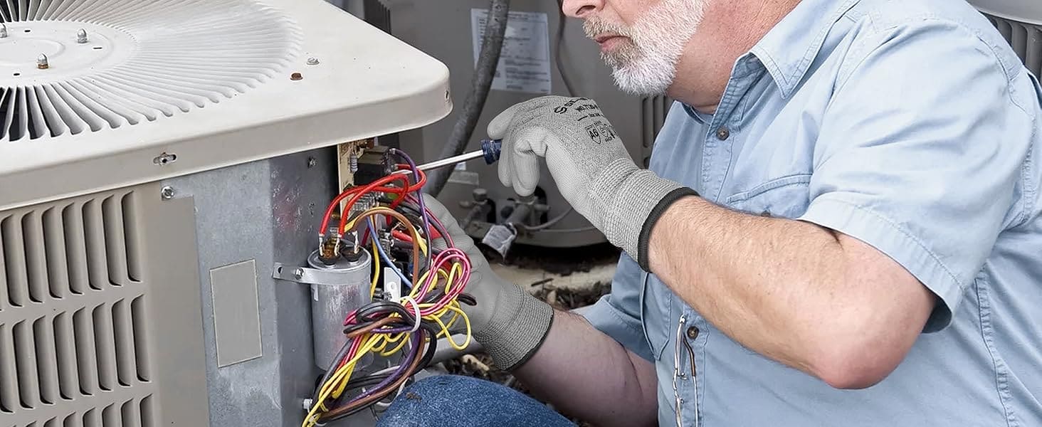 Mechanic working on an air conditioning unit with wires exposed