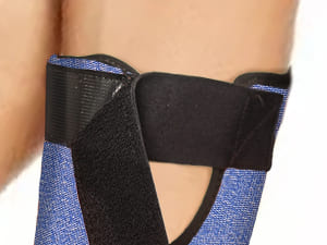 Close-up of a person wearing a blue and black brace on their arm.