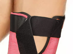 Close-up of pink and black leg wraps on a person's legs.