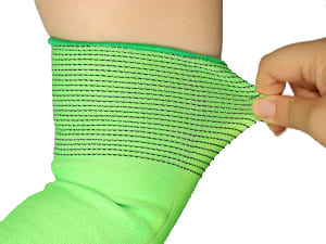Green compression bandage on a person's arm with a hand adjusting it.