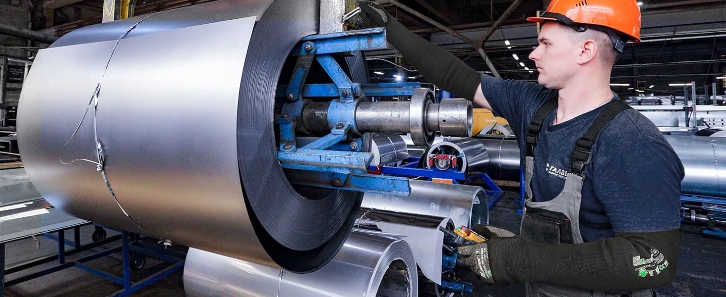 Worker operating machinery with a large metal roll in an industrial setting