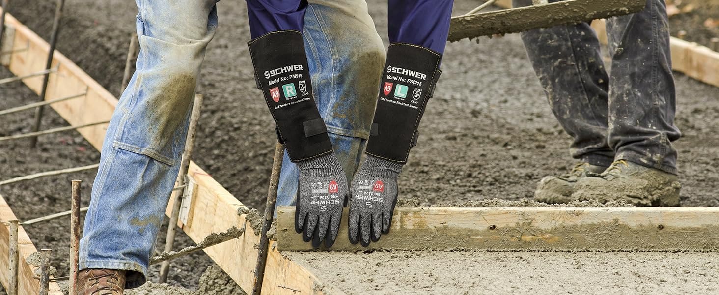 Person wearing black work gloves with visible branding on a construction site.