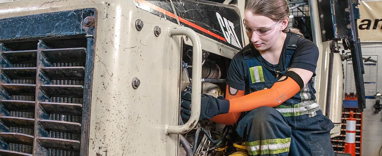 Person working on a large piece of machinery with 'CAT' branding.