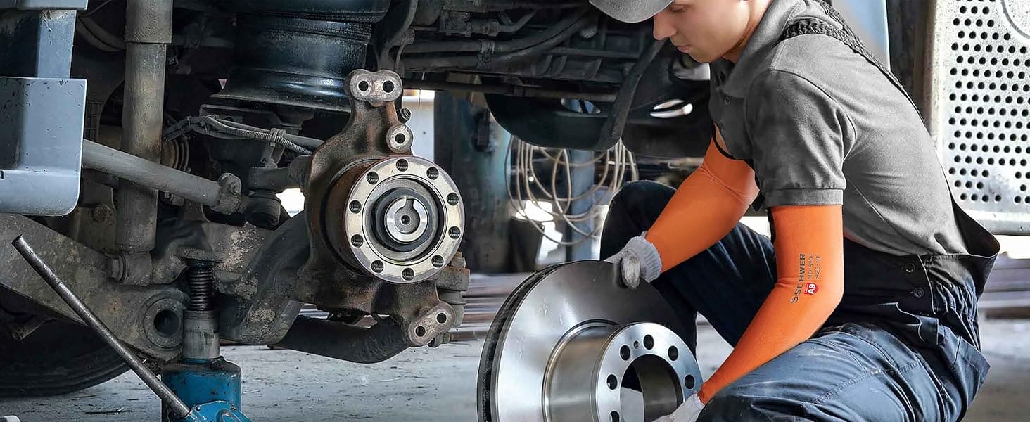 Mechanic working on a vehicle's wheel assembly.