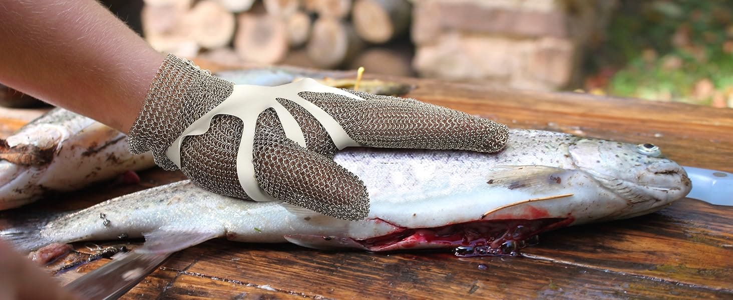 Hand wearing a textured glove holding a fish on a wooden surface
