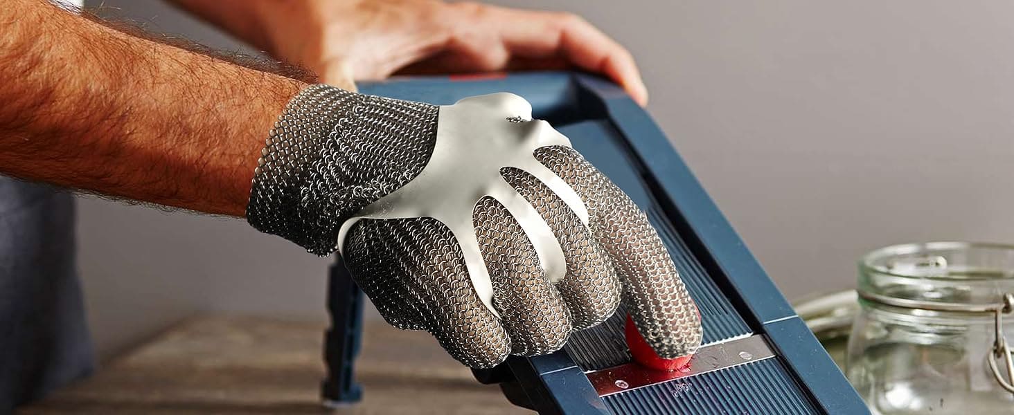 Person using a box cutter with a metal glove on a neutral background