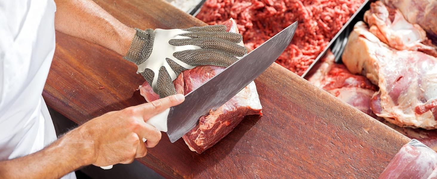 Person cutting raw meat with a large knife on a wooden cutting board.