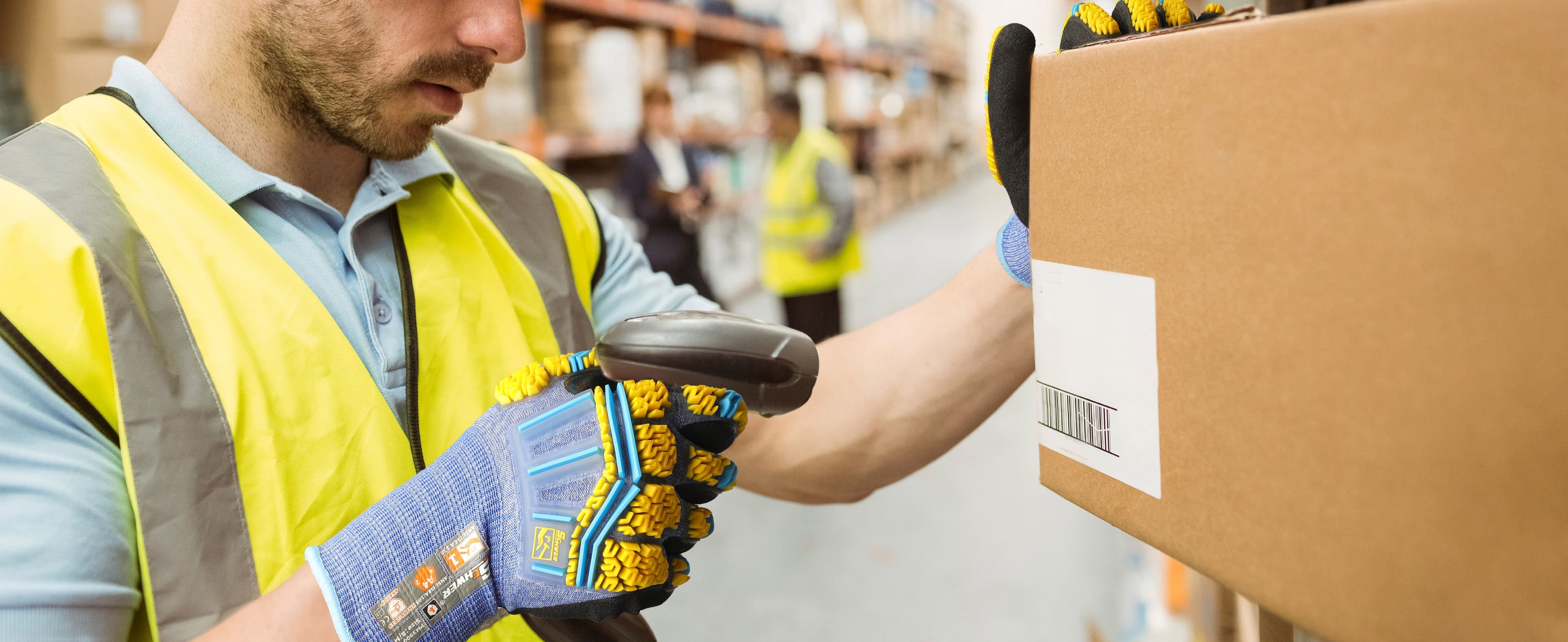 Worker scanning a barcode on a box in a warehouse setting