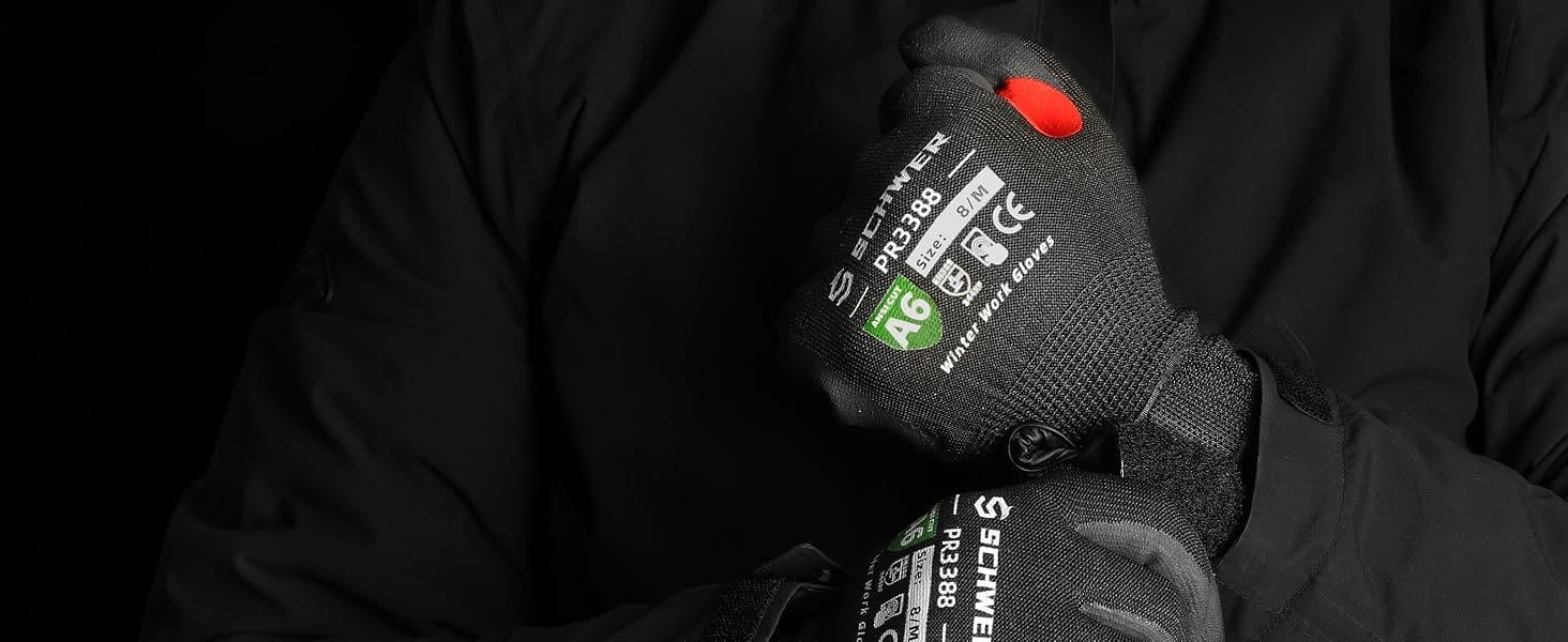 Person wearing black gloves with visible branding against a dark background