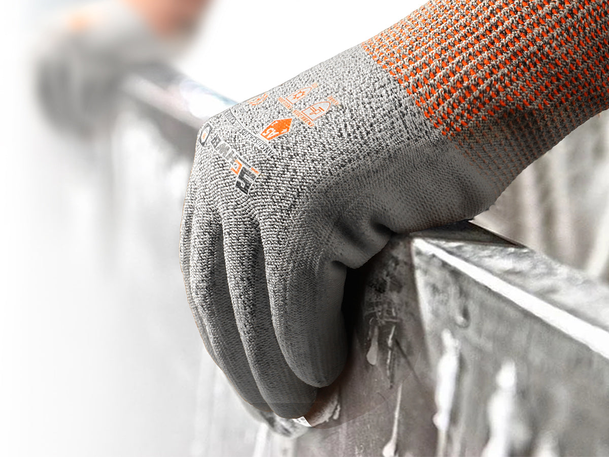 Gray work glove with orange accents gripping a metal surface