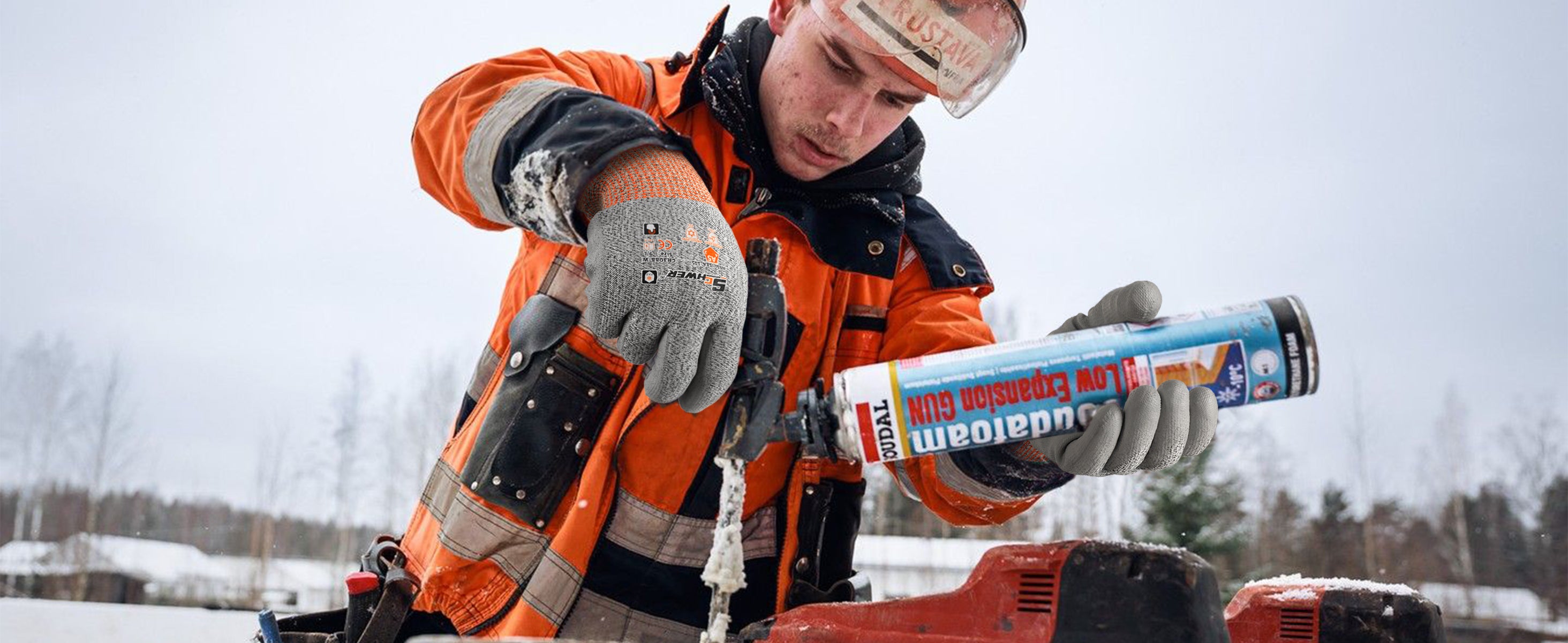 Person in winter clothing using a can of spray paint outdoors