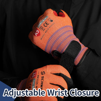Close-up of orange and black winter work gloves with adjustable wrist closure on a black background