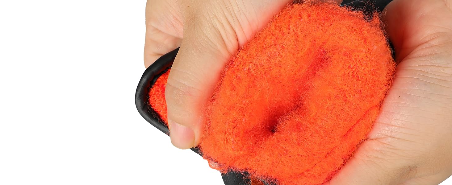 Hand holding a bright orange scrubber with a black handle on a white background