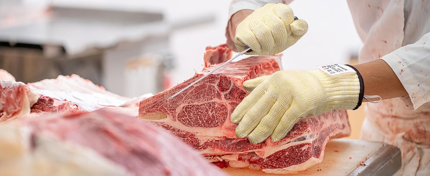 Person cutting raw meat with gloves on a cutting board in a kitchen setting
