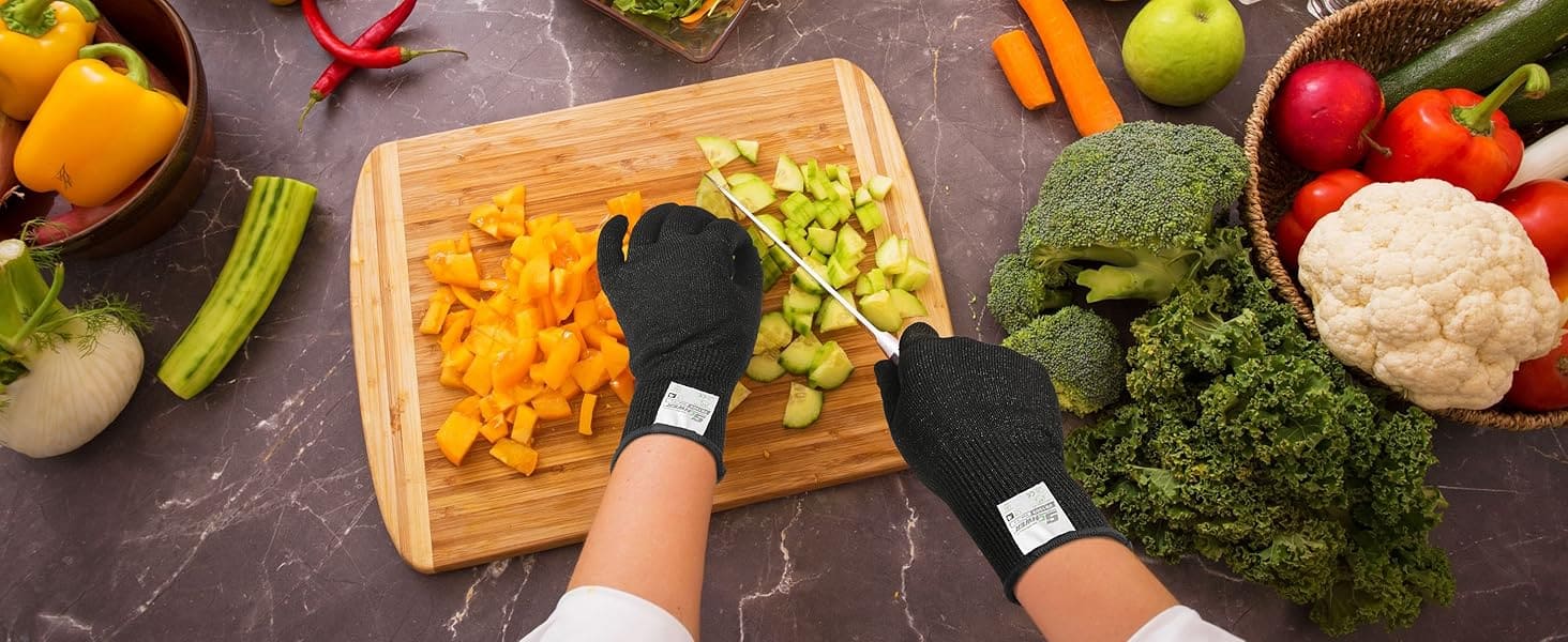 Person chopping vegetables on a wooden cutting board with various fruits and vegetables around.