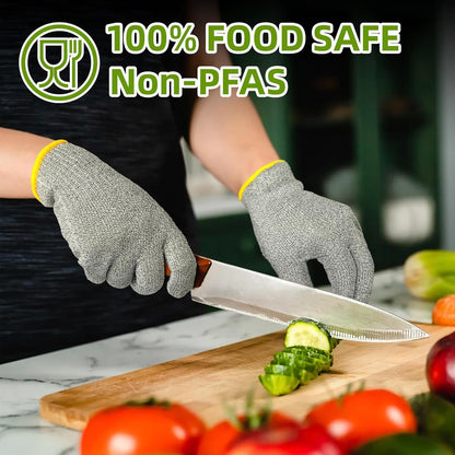 Person wearing gray cut-resistant gloves slicing cucumber on wooden cutting board with fresh vegetables nearby