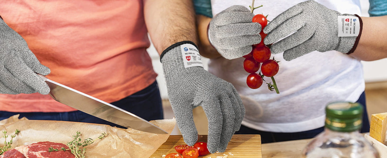 Person wearing cut-resistant gloves preparing food with a knife on a wooden cutting board.