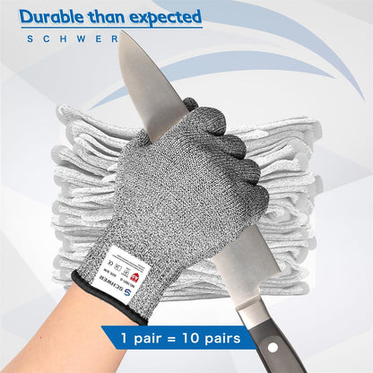 Hand wearing cut-resistant glove holding a knife with stack of gloves in background
