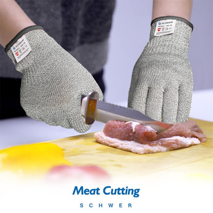 Hands wearing Schwer cut-resistant gloves slicing raw meat on a wooden cutting board