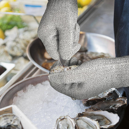 Person wearing cut-resistant gloves shucking fresh oysters on ice at seafood market