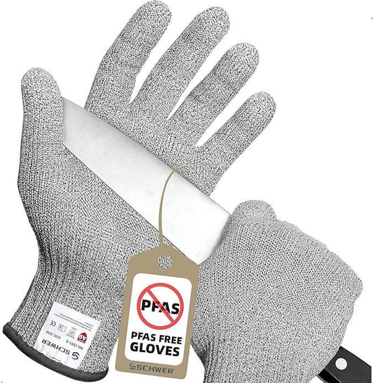 Cut-resistant PFAS free gloves holding a sharp kitchen knife with protective tags