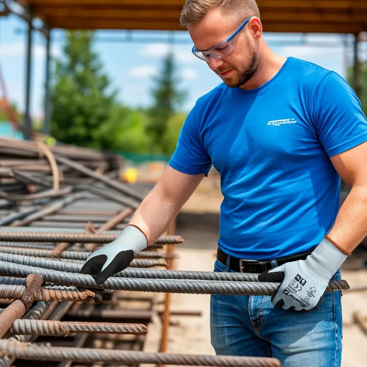 Worker wearing blue shirt and cut resistant gloves handling steel rebar at construction site