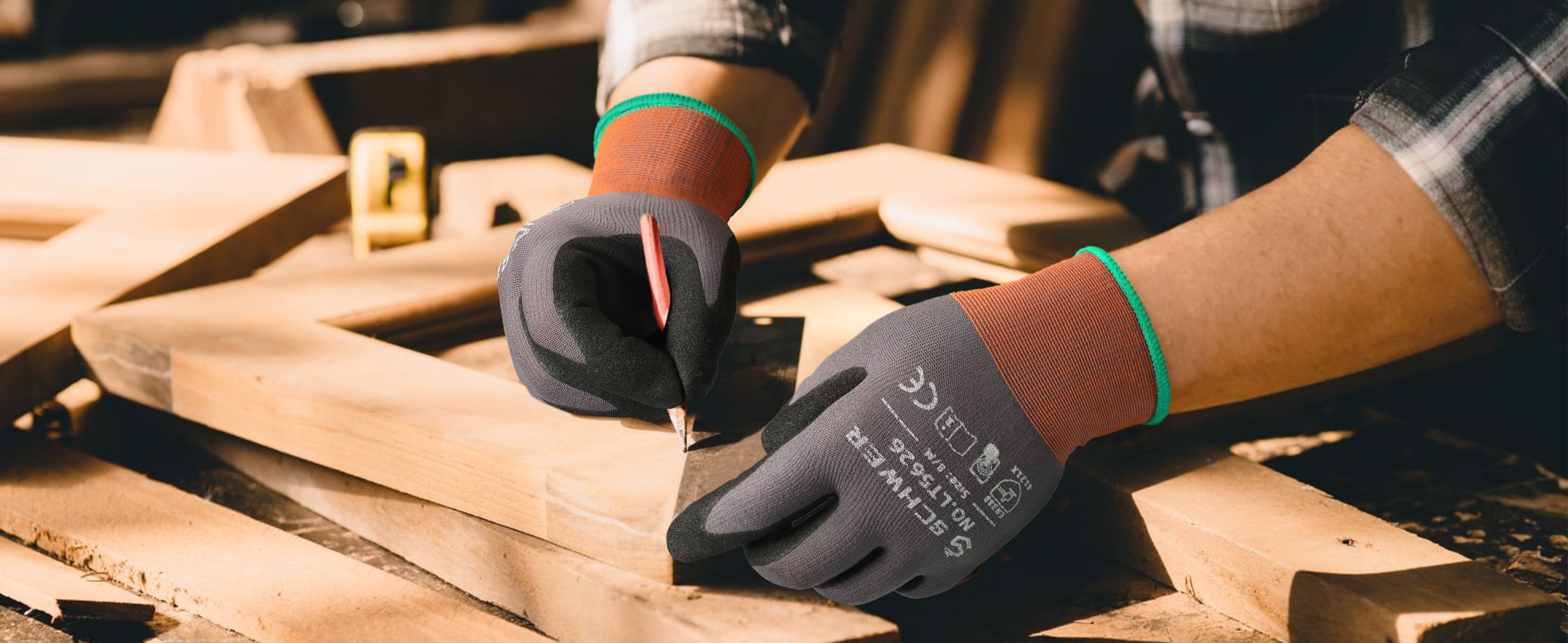 Person wearing black gloves with text and logos on a wooden surface