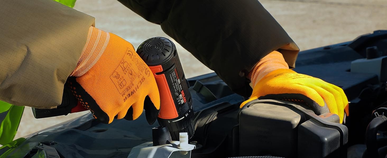 Person using a cordless drill on a piece of equipment with gloves on.