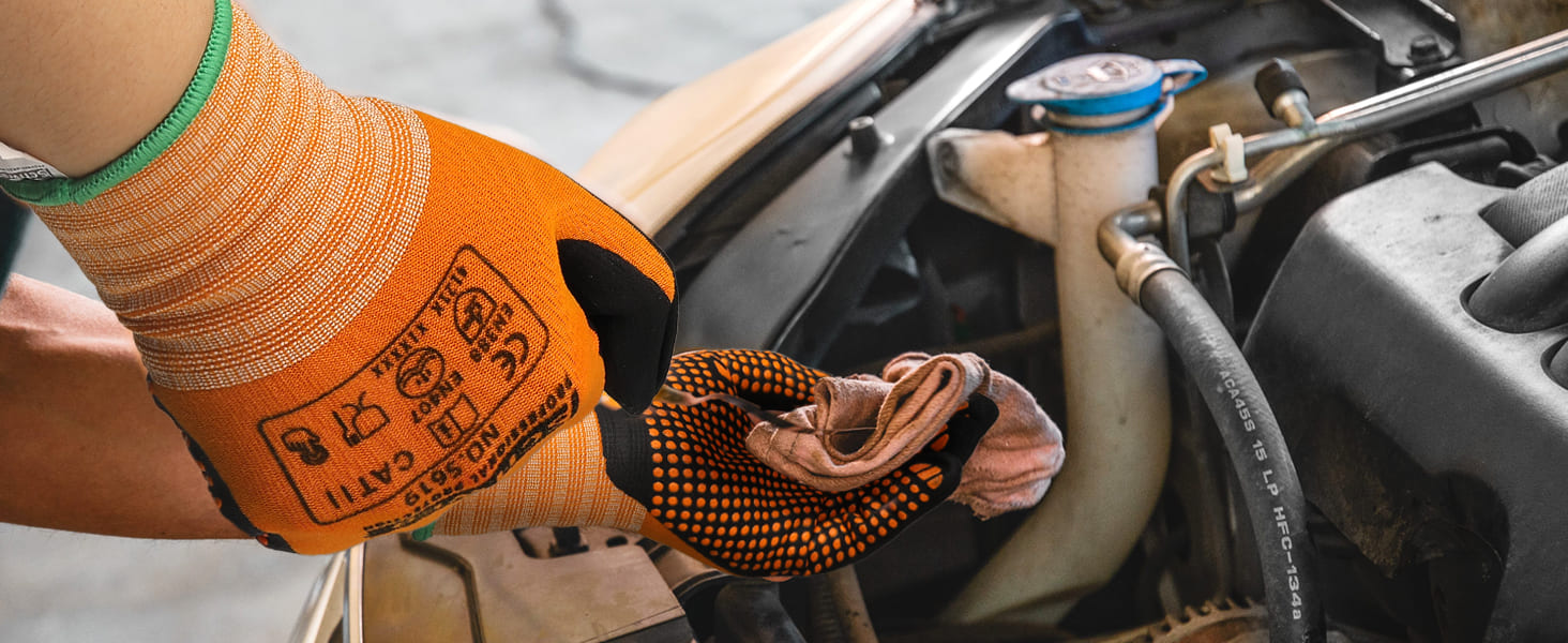 Person wearing orange gloves working on a car engine
