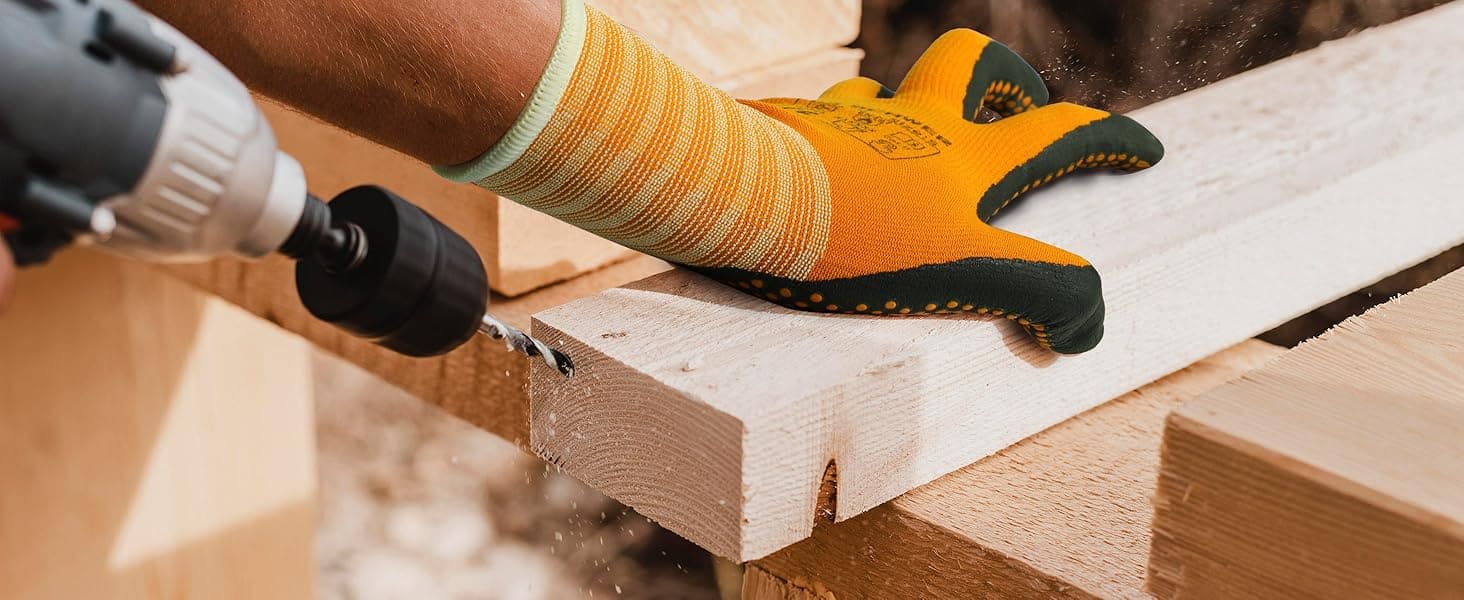 Person using a drill on wooden planks with a focus on safety gloves.