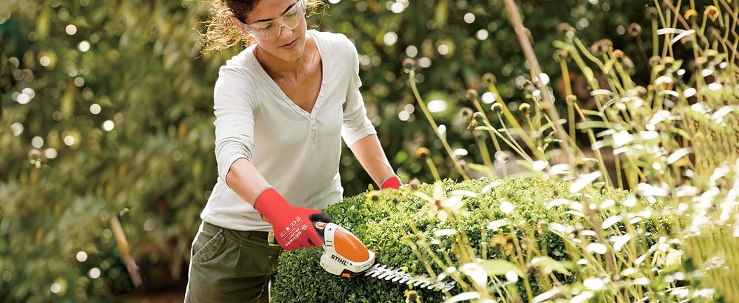 Woman trimming a bush in a garden