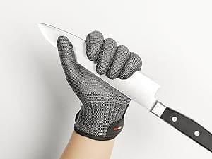 Hand wearing a cut-resistant glove holding a knife against a white background