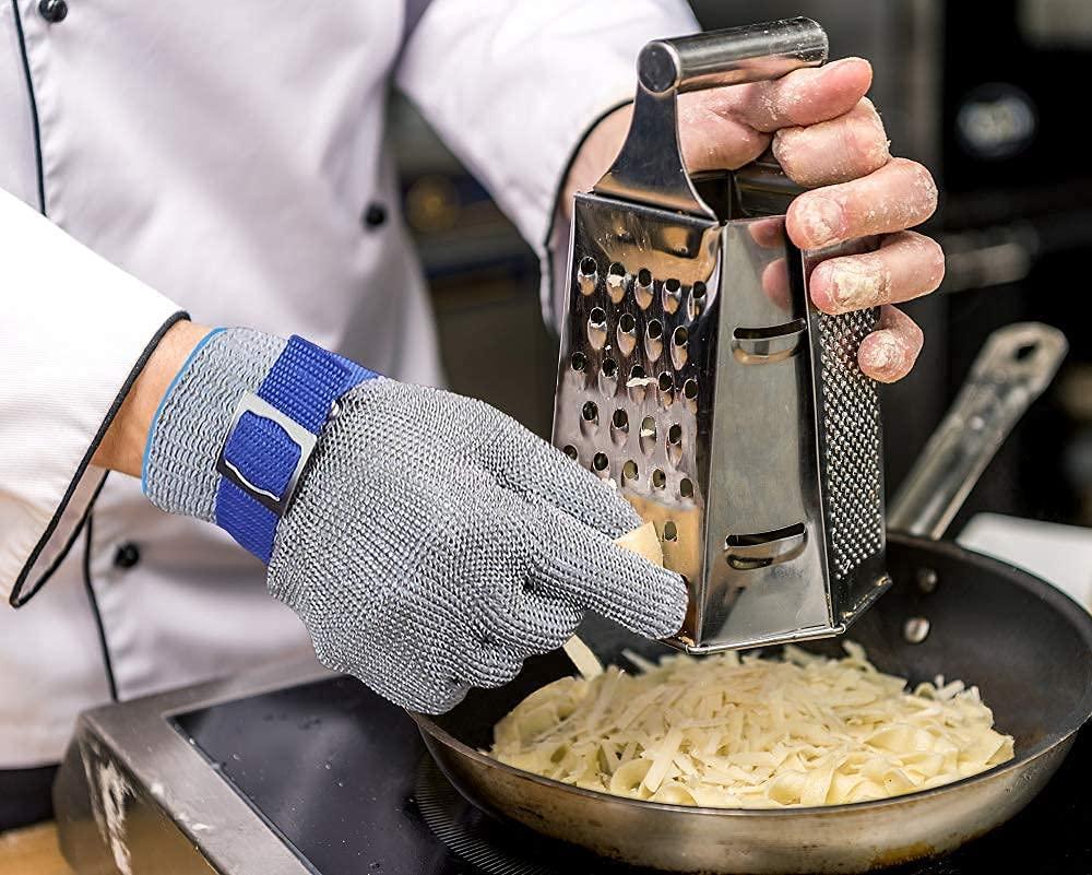Person grating cheese into a pan with a metal grater, wearing a cut-resistant glove.