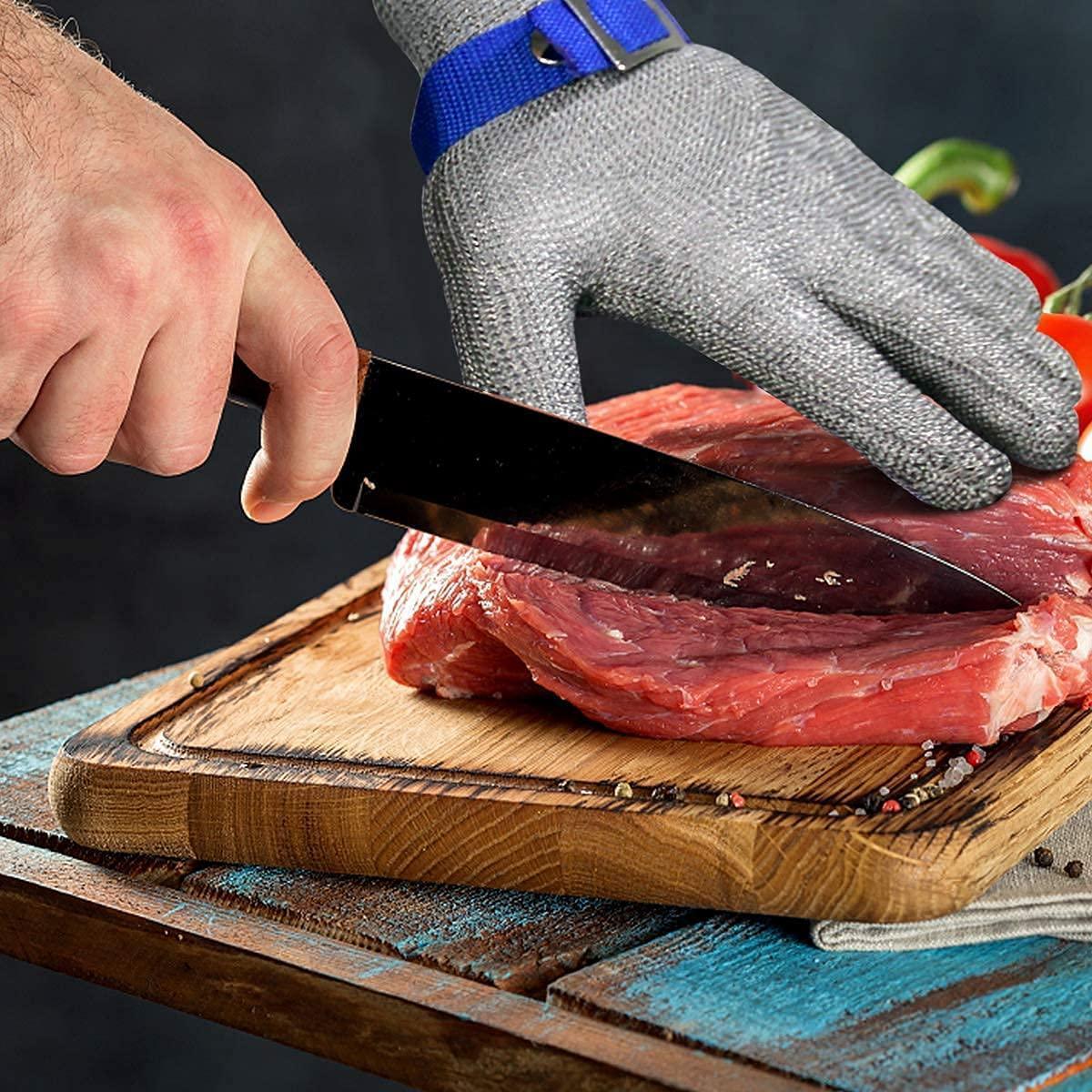 Person cutting raw meat on a wooden board with a knife, wearing a cut-resistant glove.